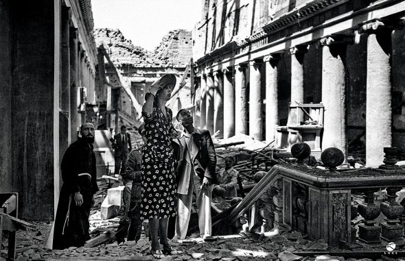 Італійська принцеса Марія Жозе (1906–2001) роздивляється римський центральний район Сан-Лоренцо після бомбардування 5 листопада 1943 року. Тоді знищили фабрику кераміки у Ватикані, пошкодили адміністративні й житлові будівлі. Фашисти заявили Папі Пію XII, що це зробили англійці та американці. Лише через 58 років знайшли документи, які це спростували. Бомби скинули італійські пілоти за наказом фашистського ідеолога Роберто Фаріначчі. Хотіли вивести з ладу незалежне радіо Ватикана. Вважали, що журналісти надсилають зашифровані військові повідомлення союзникам