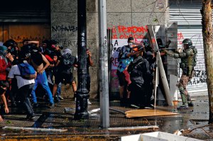 Спецпризначенець цілиться у протестувальників під час сутичок у столиці Чилі Сантьяго. 25 жовтня на вулиці вийшли понад мільйон людей. Це наймасовіша акція протесту в історії країни