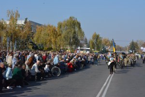 Люди навколішки зустрічають похоронну процесію Яро­слави Никоненко у місті Миргород на Полтавщині 18 жовтня. Жінку поховали поряд із батьком, який загинув у 2015-му