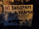 Надпись на плакате: "Нет выборам под дулами автоматов"