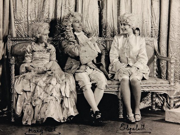 Англійська принцеса 15-річна Єлизавета (праворуч) репетирує роль принца для спектаклю “Попелюшка”. Його поставили для англійських солдатів у Віндзорському замку біля Лондона 19 грудня 1941-го. На чотири роки молодша сестра Марґарет зіграла Попелюшку. Виставами дівчата хотіли підняти дух вояків під час Другої світової. У підготовці брали участь усі придворні. Швачки створювали костюми, музикою займався оркестр Королівської кінної гвардії, декораціями – дворецькі й художники. Із принцесами працювали актори