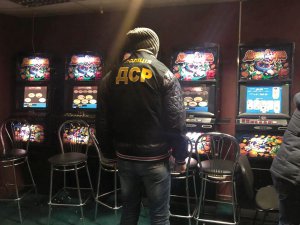 Працівник департаменту стратегічних розслідувань Національної поліції оглядає вилучені гральні автомати. У ніч на 20 грудня правоохоронці закрили 5,3 тисячі гральних закладів, більшість яких працювали під виглядом державних лотерей, вилучили обладнання на понад 50 мільйонів гривень