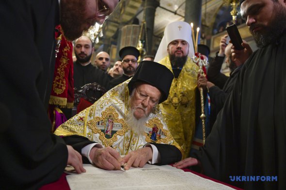 Вселенский патриарх Варфоломей подписывает томос об автокефалии Православной церкви Украины. Фото: Укринформ