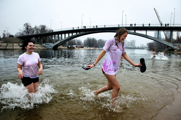 Жінки купаються у Дніпрі у київському Гідропарку на Водохреще, 19 січня. Таких місць для купання у столиці облаштували 17. Біля кожного чергували рятувальники