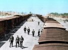 Нацисты вблизи поездов в "лагере смерти" Освенцим. На заднем плане - крематорий