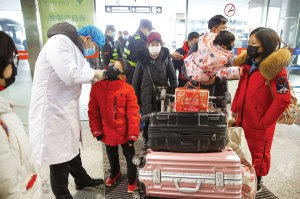 Медик вимірює інфра­червоним термометром тем­пературу ­дитини в залі вильоту ­аеропорту Чанша у ­китайській ­провінції Хунань 27 січня. У країні зафіксували спалах нового коронавірусу