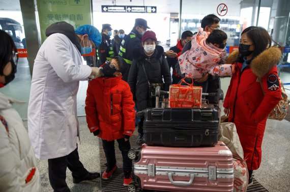 Медики измеряют температуру у людей в аэропорту города Чанша