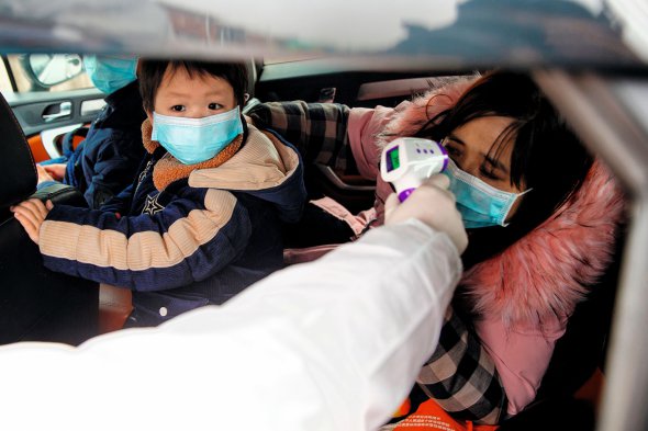 Лікарі міряють температуру тіла в людей на в’їзді в Пекін. Із міста Ухань перекрили всі виїзди
