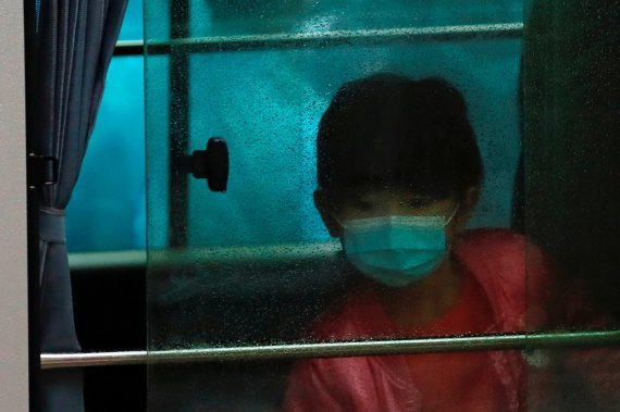 Ребенок едет в автобусе с другими эвакуированными людьми из одного из жилых районов Гонконга