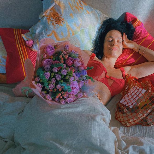 Певица и модель Даша Астафьева поделилась фотографией с постели, где она лежит в красном белье с розовым букетом роз