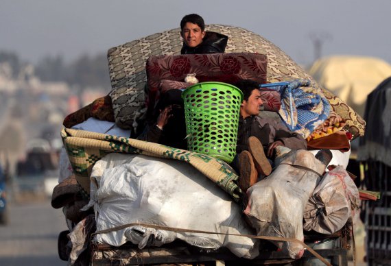 Переселені сирійці з північного заходу Сирії їздять на вантажівці з речами