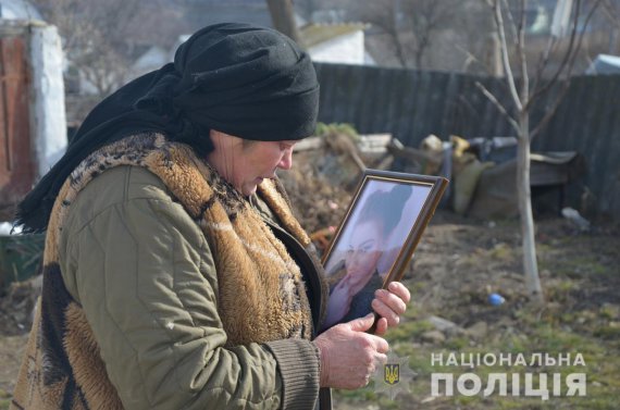  60-летняя Ольга Антоновна с Ружина Житомирской области обнимает портрет внучки 18-летней Анастасии. Ее нашли убитой в колодце в собственном дворе. Подозревают бывшего девушки - 22-летнего Александра Савина. Фото - zt.npu.gov.ua