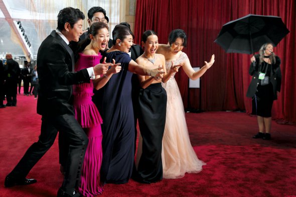Актори південнокорейського фільму ”Паразити” фотографуються на червоній доріжці перед початком вручення премії ”Оскар”. Відбулося в ніч на 10 лютого в театрі ”Долбі” в американському Лос‑Анджелесі. Сон Кан Хо (ліворуч) зіграв у картині безробітного водія, голову сім’ї Кім. Разом із дружиною й дітьми обманом влаштовується працювати в маєток багатіїв, за сюжетом