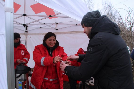 В палатке Красного Креста раздают горячие напитки и печенье