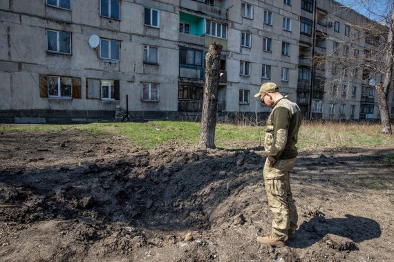 Воронка от снаряда у многоквартирного дома возле школы