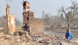 Чоловік сидить на згарищі свого дому в Овруцькому районі на Житомирщині 18 квітня 2020 року. В області пожежі тривали майже на чотирьох тисячах гектарів насаджень. Полум’я знищило й пошкодило в районі не менше 38 житлових та 43 нежитлових будинки — у селах Острови, Середня Рудня, Нижня Рудня, Личмани та Магдин