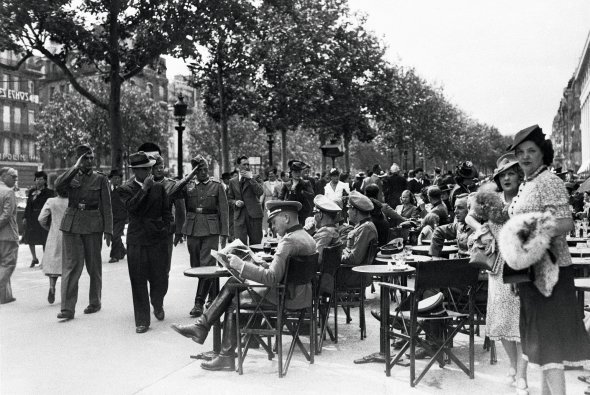 Німецькі солдати вітаються з офіцерами, які відпочивають на літньому майданчику паризького кафе, 11 листопада 1942-го. Для них у закладах було окреме меню з набагато нижчими цінами