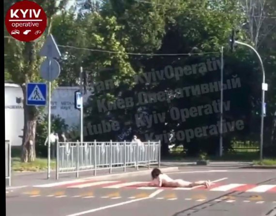 В Киеве голая женщина сначала шла на четвереньках, а потом ползла через дорогу