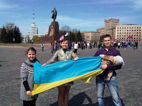 Ірина Баранова з чоловіком Олегом, донькою Мариною і сином Артемієм тримають у центрі Харкова український прапор, який вона вивезла у квітні 2014 року з військової частини в Криму