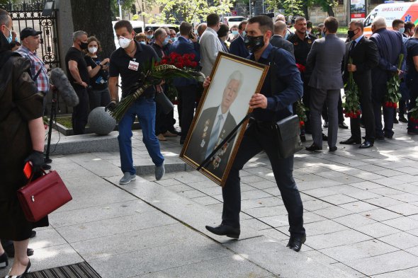 Чоловік заносить у Клуб Кабміну портрет Олексія Порошенка