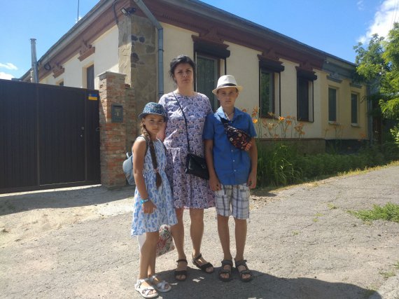 Наталія Златопольська з донькою Софією та сином Арсенієм біля будинку, в якому їм належить більша частка