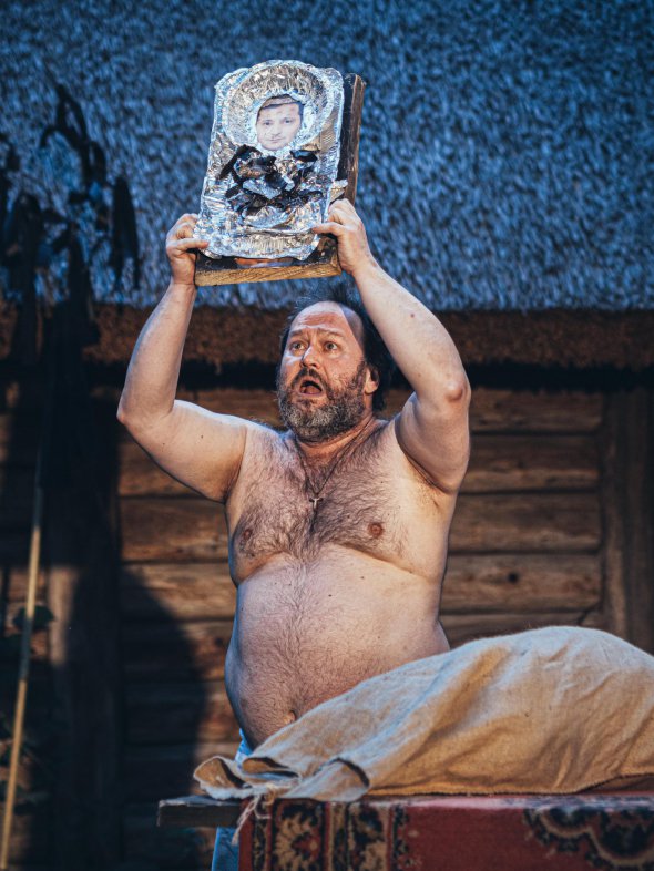 Актер Сергей Солопай в роли отца Онуфрия держит в руках икону с лицом Зеленского