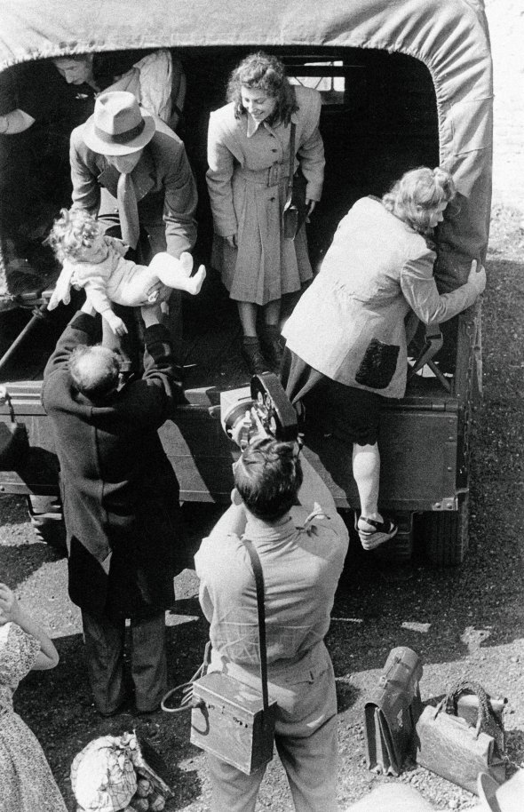 6-місячну дитину передають батькові з вантажівки, що доставила депортованих жителів  Берліна до Франкфурта 23 липня 1948-го. П’ять тисяч людей вивезли з німецької столиці,  бо Радянський Союз оголосив блокаду територіям міста, якими розпоряджалися США, Велика Британія та Франція. Жителі почали голодувати, втікали в табори переміщених осіб – D. P. Їх створили по німецьких містах, поза зоною впливу СРСР