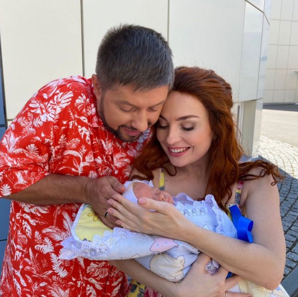 Виктория Булитко с новорожденным ребенком на руках целует мужа