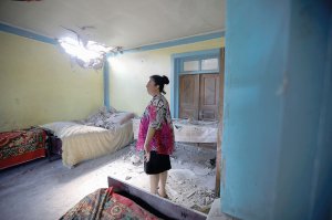 Мешканка азербайджанського селища Дондар Гушчу ­поблизу кордону показує пошкоджений під час обстрілу силами Вірменії будинок. 15 липня 2020 року