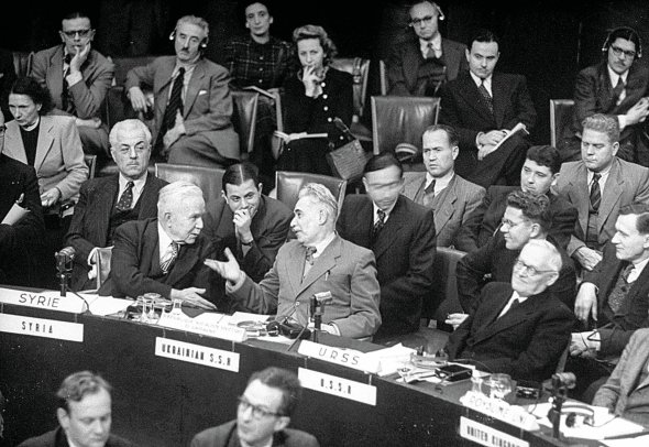 Представник Української Радянської Соціалістичної Республіки Дмитро Мануїльський (сидить у першому ряду в центрі) спілкується з сирійським делегатом Фарисом аль-Хурі на засіданні Генеральної Асамблеї Організації Об’єднаних Націй 1948 року в Палаці Шайо у Парижі