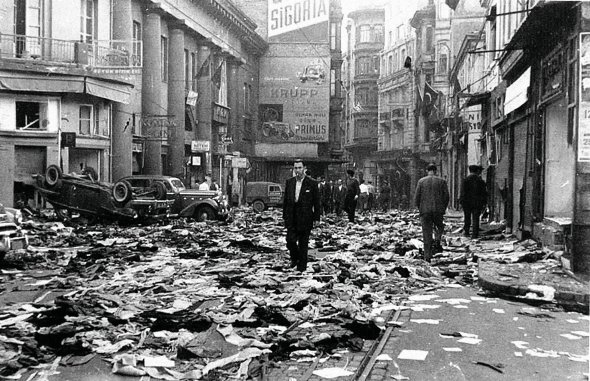 Чоловіки оглядають головну торгову вулицю Істікляль у Стамбулі 7 вересня 1955-го. Більша частина магазинів, майстерень і закладів харчування там належали грекам і вірменам. За ніч їх розгромили турки. Після цього власники продали чи покинули бізнес. Виїхали з країни