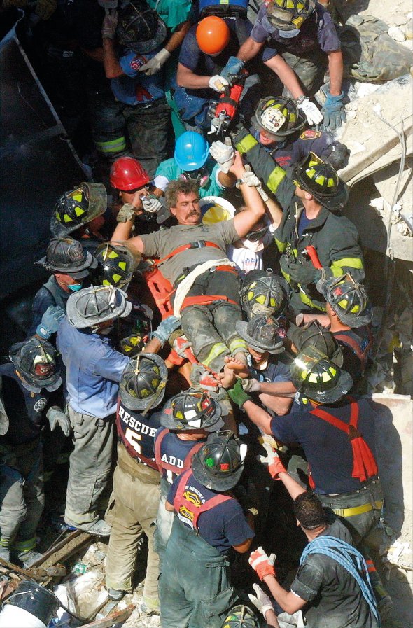 Рятувальники дістають чоловіка з-під завалів Всесвітнього торгового центру в Нью-Йорку 13 вересня 2001 року. За два дні до того викрадені терористами літаки врізалися у 110-поверхові вежі-близнюки, ті загорілися. Через годину будівлі обвалилися. Загинули майже три тисячі людей. Вижили 20 осіб, зокрема – чоловік на світлині