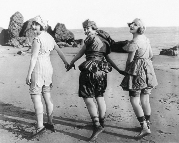 Американські акторки 21-річна Ліліан Ленґстон, 19-річна Едіт Робертс і Міртл Рівз, 22 роки, демонструють нові моделі купальних костюмів на каліфорнійському пляжі 2 жовтня 1918-го. В той час для купання жінки вдягали широкі панталони, туніку, спеціальну сукню. А також – панчохи, купальні туфлі, рукавички, капелюх або шапку. Вбрання шили з грубих бавовняних чи вовняних тканин, щоб приховати форми