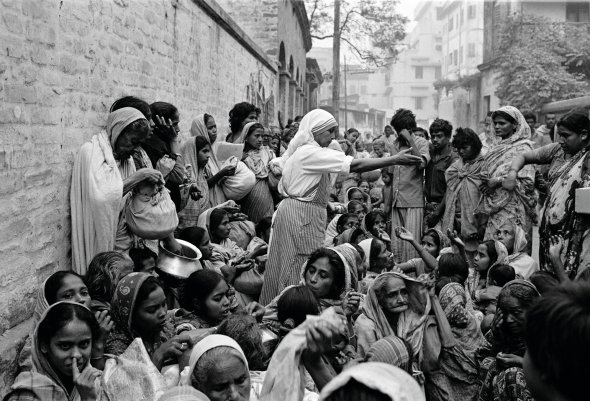 Чорниця розміщує на вулиці людей, які пришли по продукти до притулку матері Терези в Калькутті, Індія