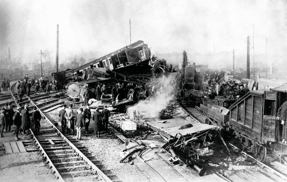 Люди оглядають місце залізничної аварії біля станції міста Шрусбері, неподалік Лондона. Вночі 15 жовтня 1907-го пасажирський потяг із поштовими вагонами зійшов із рейок. Машиніст заснув і не пригальмував на крутому повороті – замість дозволених 16 км/год. їхав зі швидкістю 97 км/год. Три вагони перевернулися. Загинули машиніст і пожежник, два охоронці, 11 пасажирів і три сортувальники пошти. Ще 33 людини отримали поранення