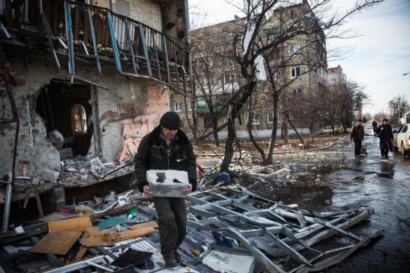 Чоловік розбирає звалища будинку після обстрілу, вчиненого росіянами