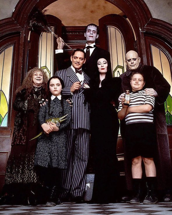 Семейка Аддамс из фильма 1991 года. Персонажи слева направо: Бабушка, дочь Уэнсдей, папа Гомес, дворецкий Ларч, мама Мортиша, дядя Фестер и сын Пагсли