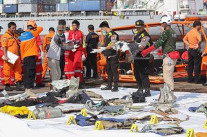 Спасатели выносят на берег обломки самолета и вещи погибших пассажиров в порту Танджунг-Приок, Индонезия, 29 октября 2018