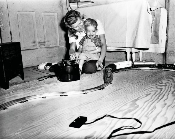 2-річний Террі Макгінніс грається з матір’ю Джеймс у Педро-Сіті в американському штаті Каліфорнія 5 грудня 1951-го. У нього від народження збільшене серце й порушений кровообіг. Після чергового обстеження лікарі сказали, що хлопчик будь-якої миті може померти. Батьки подарували Террі дитячу залізницю за 20 днів до Різдва. Йому зробили ще кілька операцій. Прожив до 6 років