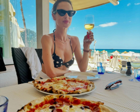 Откровенный купальник, пицца, вино и красивые пейзажи: 42-летняя супермодель показала, как проводит отпуск у моря