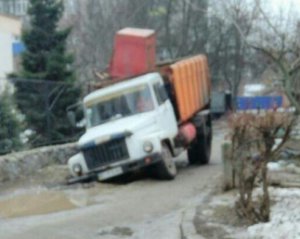 Сміттєвоз провалився в яму на асфальті